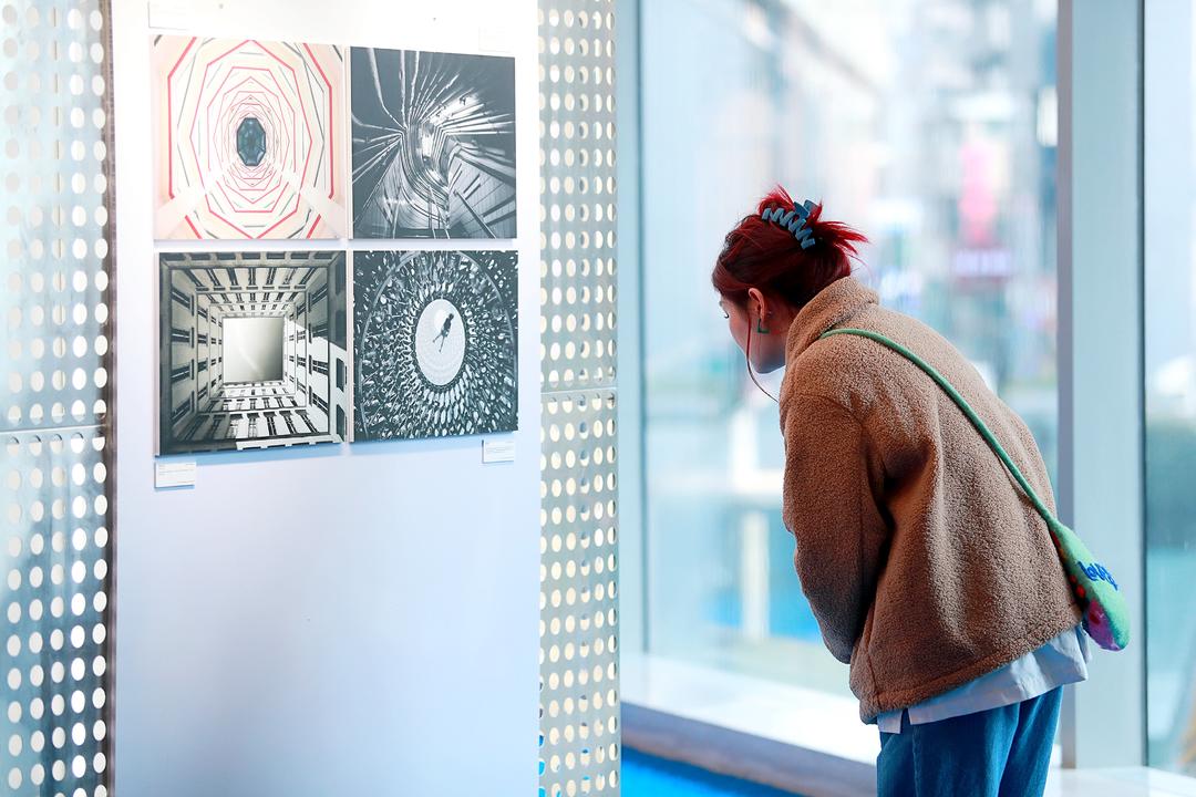 Person viewing photos on display at the Art of Building exhibition in China